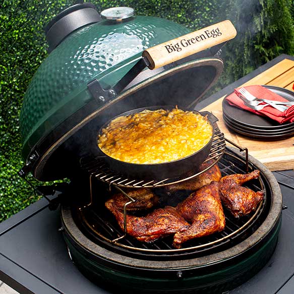 Big Green Egg grill open with BBQ chicken and top rack