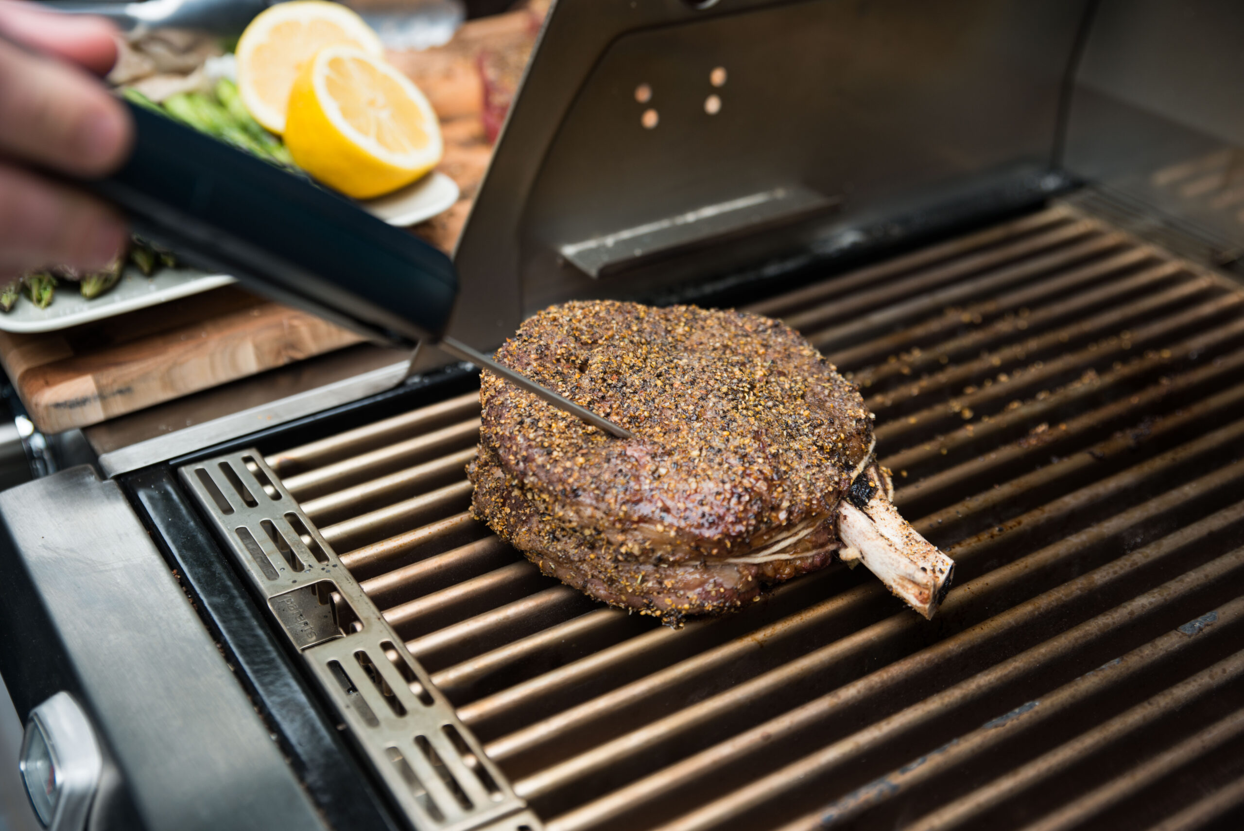 digital thermometer inserted into steak on grill